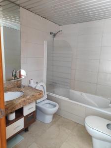 a bathroom with a sink and a toilet and a bath tub at 巴塞之家 in Montcada i Reixac