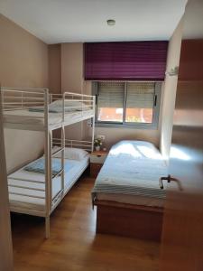 two bunk beds in a room with a window at 巴塞之家 in Montcada i Reixac