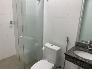 a bathroom with a shower and a toilet and a sink at Hotel Seven in Goiânia