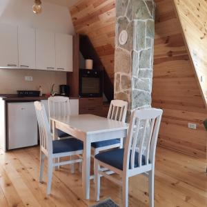 a kitchen and dining room with a table and chairs at Zelenova koliba in Žabljak