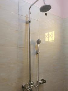 a shower with a shower head in a bathroom at Middleton Suites in Kiswera
