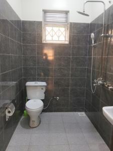 a bathroom with a toilet and a sink at Middleton Suites in Kiswera