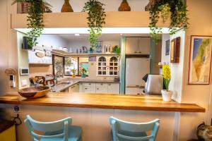 a kitchen with a wooden counter top and blue chairs at Desert Picture in Arad