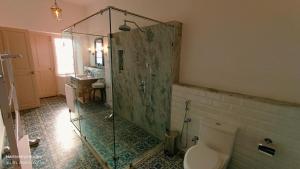 a bathroom with a shower with a toilet and a sink at Lockhart Bungalow Munnar - A CGH Earth SAHA Experience in Munnar +35 photos