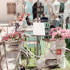 a white bike parked next to baskets of flowers at Heritage Hotel Chersin in Fažana