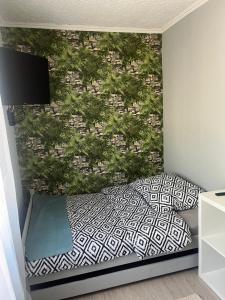ウェバにあるApartament w centrum Łebyのベッドルーム1室(壁に植物を植えたベッド1台付)