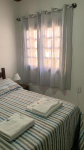 a bedroom with a bed with two towels on it at villa in Petrópolis