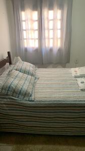 a bed in a bedroom with a window at villa in Petrópolis