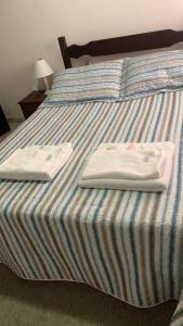 a bed with two towels sitting on top of it at villa in Petrópolis