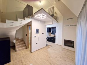 sala de estar de planta abierta con escalera y chimenea en Volos Terra Deluxe Residences, en Volos