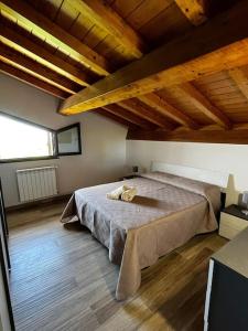 ein Schlafzimmer mit einem großen Bett in einem Zimmer mit Holzdecken in der Unterkunft My Home - Mini appartamento in mansarda in Santa Venerina