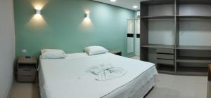 a bedroom with a large white bed with two towels on it at Hotel Recanto Vip - Antigo Recanto da Serra in Araripina