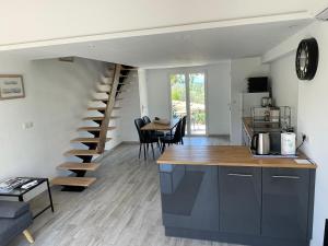 a kitchen and living room with a spiral staircase at Cottage les Marjoris Tanneron in Tanneron