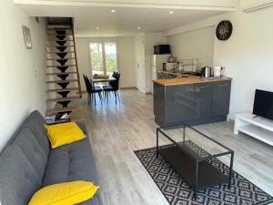 a living room with a couch and a kitchen at Cottage les Marjoris Tanneron in Tanneron