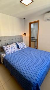um quarto com uma cama azul e um edredão azul em Cobertura Duplex Encantadora com jacuzzi Privativa Vista mar em Vila Velha