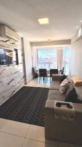 uma sala de estar com um sofá e uma sala de jantar em Cobertura Duplex Encantadora com jacuzzi Privativa Vista mar em Vila Velha