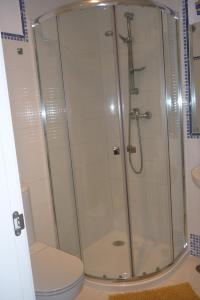Una ducha con puerta de cristal al lado de un inodoro. en Beachfront 3 Bed Apt San Luis De Sabinillas, en San Luis de Sabinillas