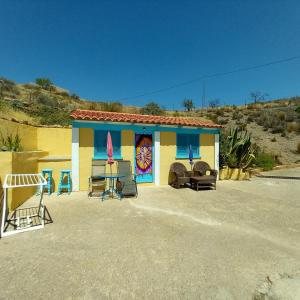 un edificio colorido con sillas delante en La Colmena, en El Puertecico