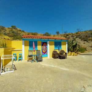 una casa colorida con sillas delante en La Colmena, en El Puertecico