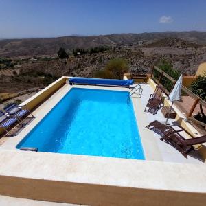 a swimming pool with chairs and a view of the desert at La Colmena in El Puertecico