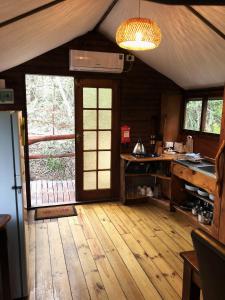 a kitchen with a wooden floor and a door at Teniqua Treetops in Sedgefield