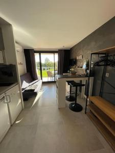 a room with a kitchen with a counter and a table at Appt Golfe de Saint-Tropez proche de la mer climatisé in Grimaud