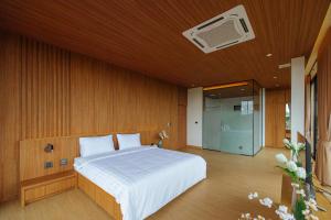 una camera da letto con un letto e una TV a parete di Krajokkaew mouthten khao yai a Ban Khlong Yang Altre 17 foto
