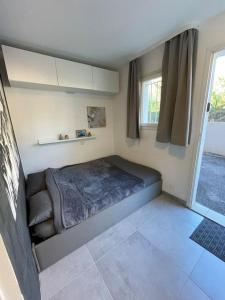 a bedroom with a bed in the corner of a room at Appt Golfe de Saint-Tropez proche de la mer climatisé in Grimaud