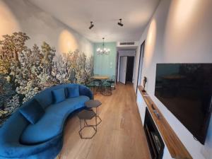- un salon avec un canapé bleu et un mur dans l'établissement One Apartment near Lake in Bucharest, à Bucarest
