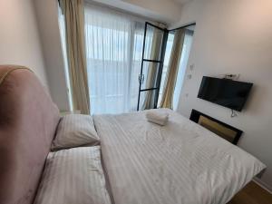 1 dormitorio con cama y ventana grande en One Apartment near Lake in Bucharest, en Bucarest