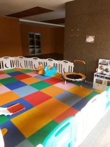 sypialnia z łóżkiem i kolorową podłogą w obiekcie DeAr Caspian Apartment w mieście Surabaja