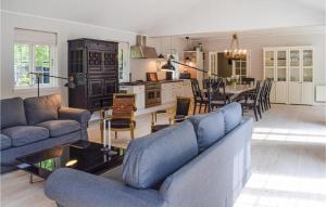 a living room with two blue couches and a kitchen at Nice Home In Hornbk With 5 Bedrooms And Wifi in Hornbæk