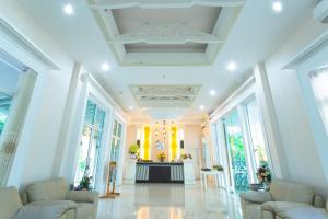 a lobby with white furniture and large windows at Nantrungjai Boutique Hotel in Nan