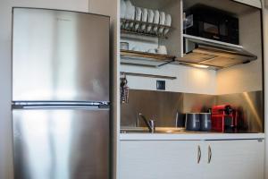 uma cozinha com um frigorífico de aço inoxidável e armários em Limani's Sea View Suite em Tessalônica