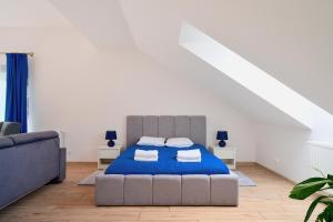 a bedroom with a bed and a couch at Warmia Apartments in Olsztyn