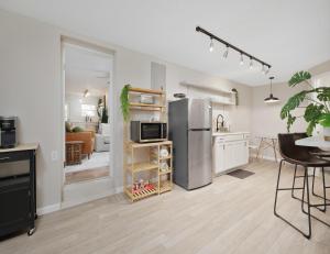 uma cozinha com um frigorífico de aço inoxidável e uma mesa em Hydrangea Cottage Unit B em Saint Augustine