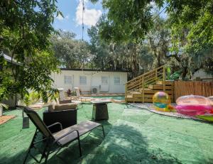 um quintal com uma cadeira, uma caixa de areia e uma casa em Hydrangea Cottage Unit B em Saint Augustine