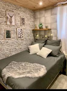 1 dormitorio con 1 cama con pared de piedra en Fleur et Benj en Aussois