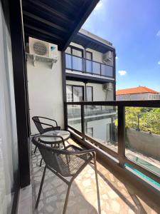 a balcony with two chairs and a table and a window at Rumah Kahyangan in Canggu