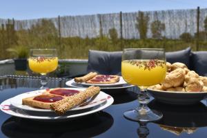 a table topped with plates of food and two glasses of orange juice at To Spitaki Dalamanara in Dhalamanára