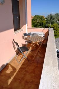 um pátio com uma mesa e cadeiras em uma varanda em Casa da Carlo em Pisa