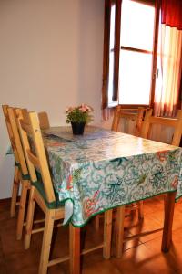 uma mesa de jantar com uma toalha de mesa e cadeiras em Casa da Carlo em Pisa