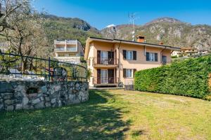 a large house with a stone wall in front of it at Mary Rose Apartments in Oliveto Lario