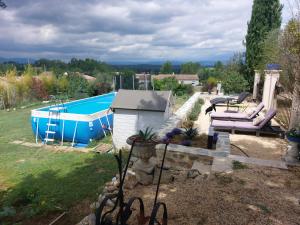 einen Hinterhof mit einem Pool und einem Haus in der Unterkunft La Flor Azul in Grospierres