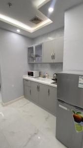 a kitchen with a refrigerator and a counter top at Manazel Al Faisal Furnished Apartments in Al Baha