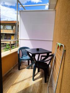 a table and chairs on a balcony with a window at M&D in Nesebar