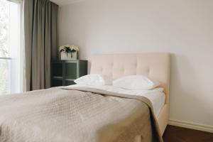 1 dormitorio con 1 cama con sábanas blancas y ventana en Dream Stay - Stylish Studio with French Balcony, en Tallin
