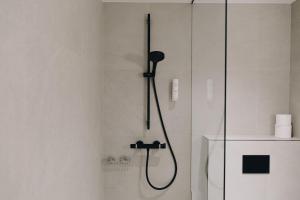 łazienka z prysznicem z czarną głowicą prysznicową w obiekcie Dream Stay - Stylish Studio with French Balcony w Tallinnie