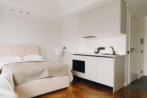 een witte slaapkamer met een bed en een wastafel bij Dream Stay - Stylish Studio with French Balcony in Tallinn