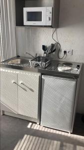 a kitchen with a sink and a microwave at Studio au centre de Quimper RDC in Quimper
